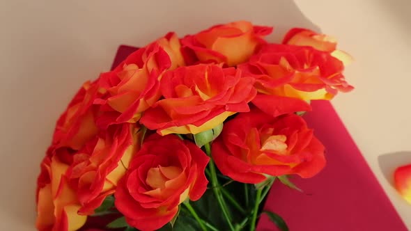 Bouquet of Red Roses Decorated in Paper Envelope on Beige Background