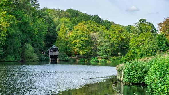 Boathouse on the edge of Rowe's Flashe Lake at Winkworth Arboretum in Surrey England UK