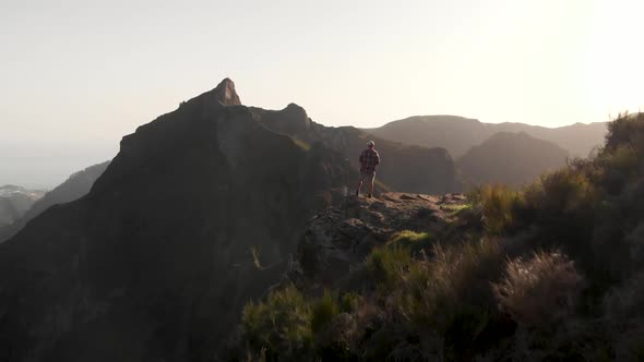 Epic Aerial Shot of Man Hiker Standing on the Edge of a Cliff