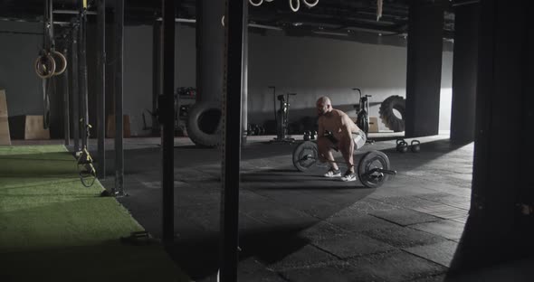 Athletic Man Doing Clean and Jerk Exercise Barbell in Gym