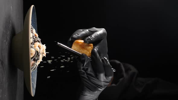 Chef Grating Hard Cheese on Freshlycooked Black Seafood Pasta