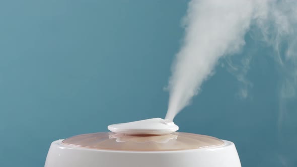 Humidification of Indoor Air with a Humidifier Device on a Blue Background