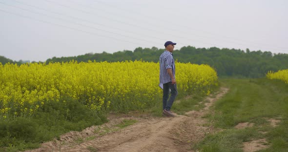 Farmer Examining Agriculture Field on Farm