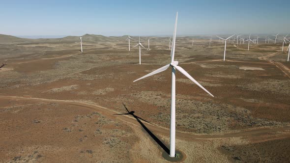 Drone Flight In Wind Farm On Sunny Day With Turbine Propellers Rotating