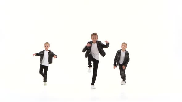 Kids Are Dancing a Modern Dance on the White Background in Black Leather Jackets and Jeans