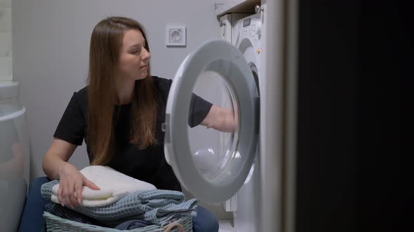 Woman Opens Door of Washing Machine Puts in Dirty Clothes and Takes Out Clothes