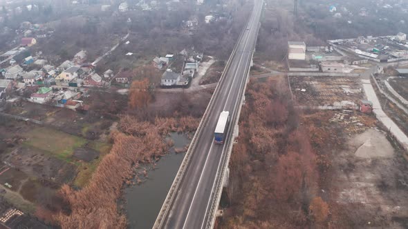 A Truck with a Trailer Driving Over a Long Bridge - Tilt Reveal Drone Shot