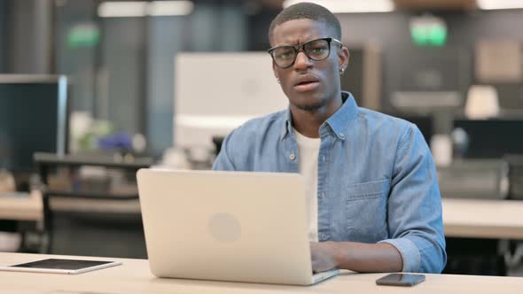 Young African American Man Showing No Gesture with Finger in Office