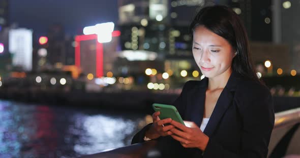 Business woman use of mobile phone at night 