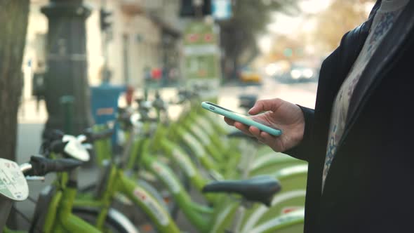 Woman Take Electric Kick Scooter or Bike Bicycle in Sharing Parking Lot Tourist Phone Application