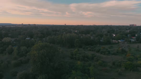 Circling aerial shot of nepean, ontario hovering over a park with trees and buildings of the city in