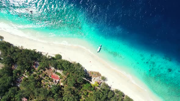 Wide angle flying abstract shot of a sandy white paradise beach and blue water background in vibrant