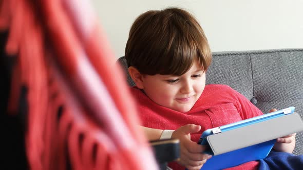 Boy using digital tablet in living room 4k