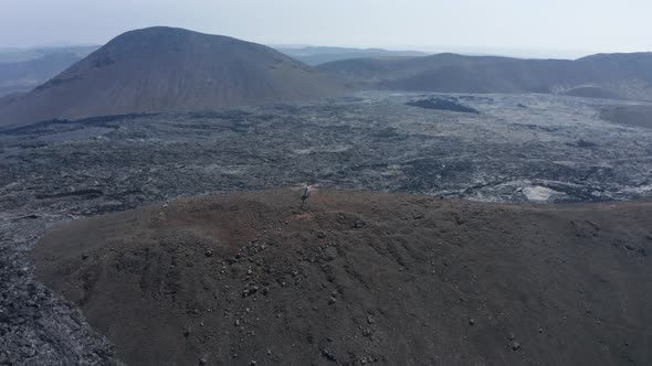 Orbit Shot Around Helicopter Landed on Elevated Ground Surrounded By New Lava Filed