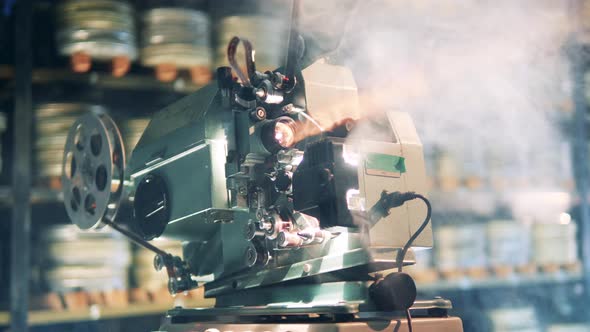 Antique Movie Projector in the Clouds of Smoke