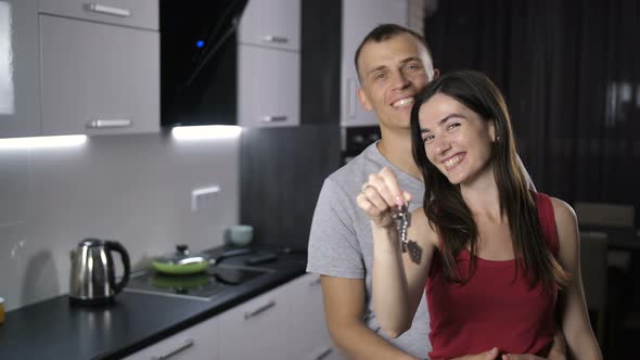 Portrait of Couple Shaking Keys To New House