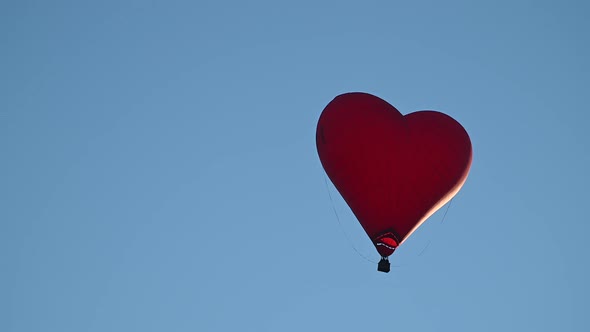 Colorful Hotair Heart Shape Balloon Flying on Sunset Over Blue Sky in Slow Motion Happy Valentines