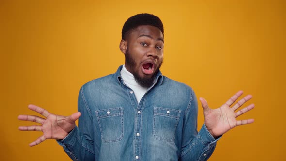 Worried Scared Young African American Man Against Yellow Background