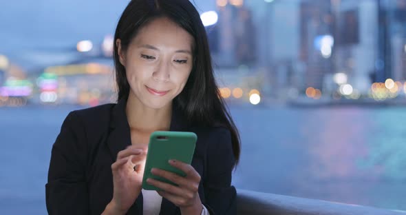 Business Woman Reading on Mobile Phone at Night 