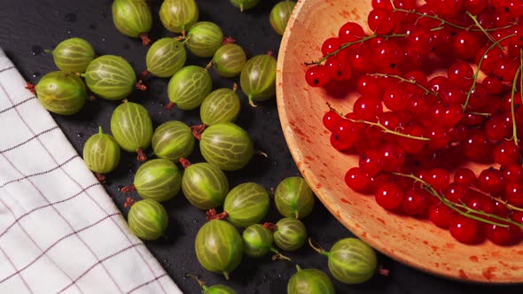 Delicious Red Cranberry and Juicy Green Gooseberry on a Black Stone Table