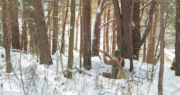 Reenactor Dressed As American Soldier Of USA Infantry Of World War II Shooting From Rifle In Winter