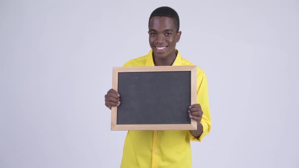 Young Happy African Businessman Holding Blackboard