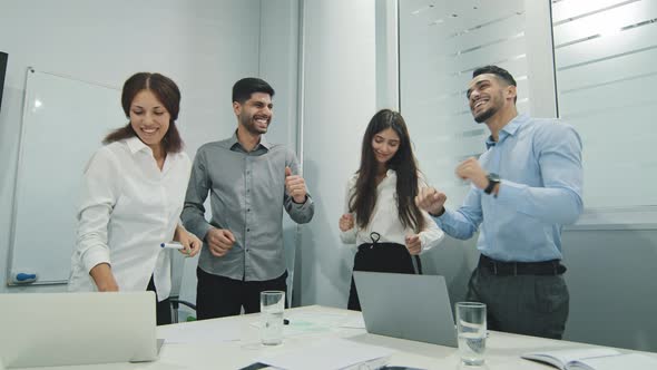 Excited Motivated Successful Diversity Colleagues Joying and Celebrating Team Success in Office