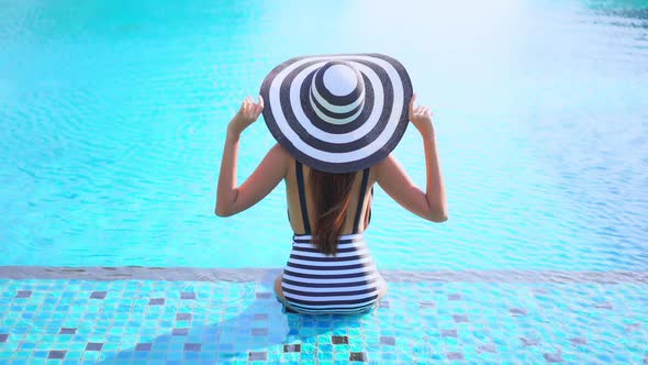 Young asian woman enjoy around outdoor swimming pool for leisure