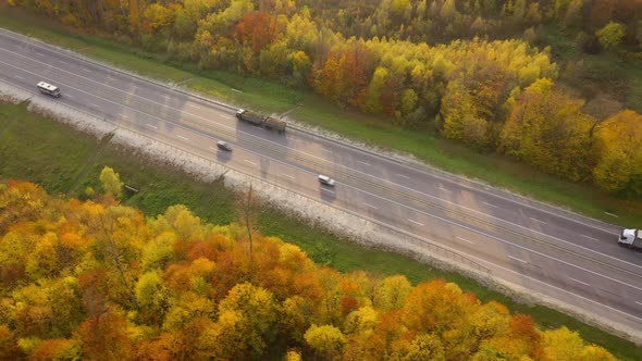 View From the Height on Traffic on a Highway Surrounded By Bright Autumn Forest