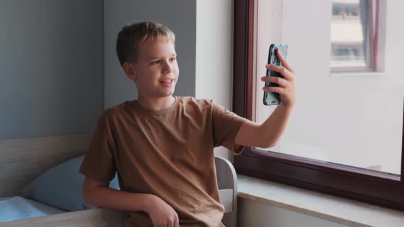 A Pre Teenager Communicates Via Video Link or Writes a Blog Using a Smartphone