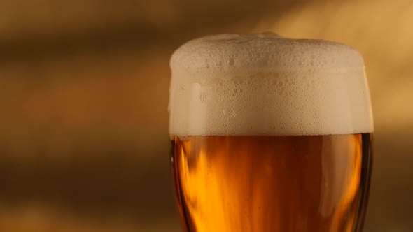 Closeup of Fresh Beer with Golden Background