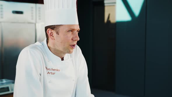 Close-up, portrait: Male chef communicates in professional kitchen of a restaurant