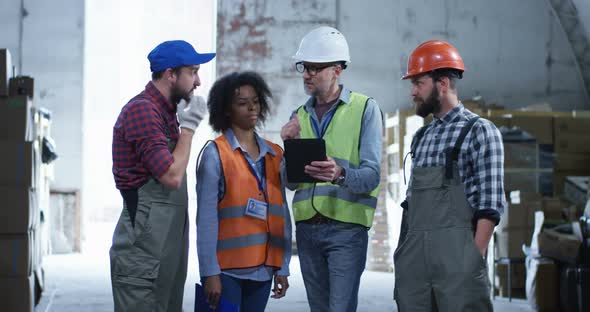 Engineer Giving Out Instructions in a Warehouse