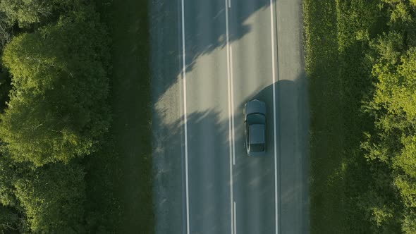 Aerial View of a Car Driving on the Road in a Field