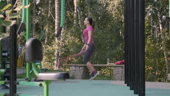 Woman Skipping with Jump Rope in Outdoor Gym