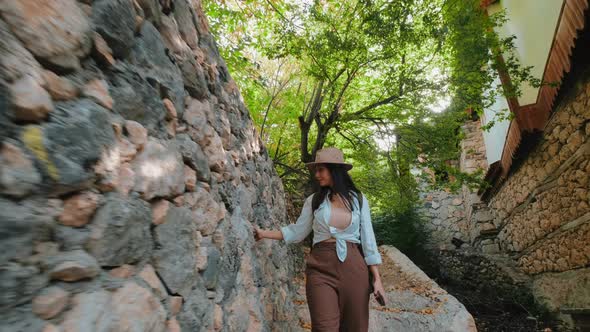 Woman Walking By Touching Wall