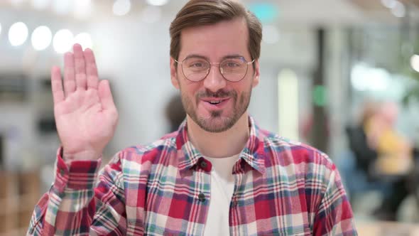 Portrait of Cheerful Male Designer Waving at the Camera 