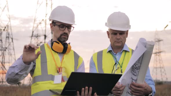 Male Engineers Discuss Work While Staying in a Field.