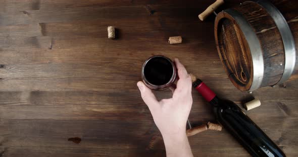 A Man's Hand Puts a Glass of Wine on the Table