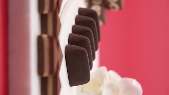 Vertical video, Close up: Composition of chocolate and candies on a red background