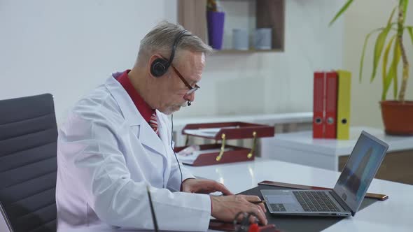 Doctor writing an appointment for a client during video call.