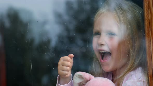 Little girl crying by the window