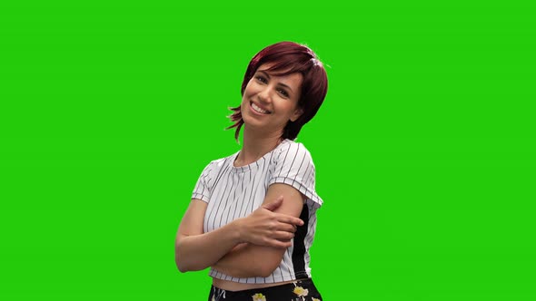 Cheerful short haired brunette woman crossing hands and posing in green screen