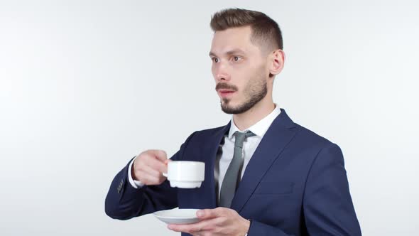 Businessman Staring into Space and Drinking Coffee