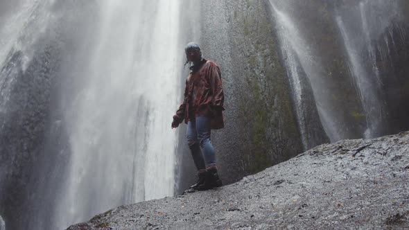 Young Woman On Rock Before Waterfall