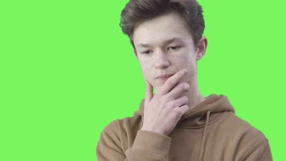 Close-up of Thoughtful Brunette Boy with Brown Eyes. Portrait of Philosophical Caucasian Teenager