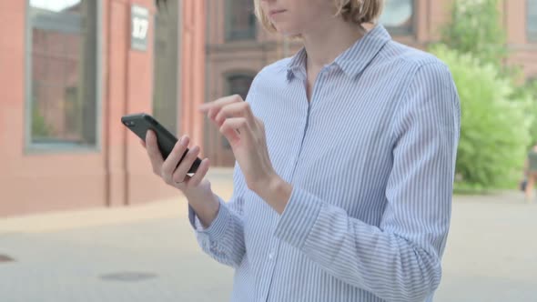 Close Up of Walking Woman Using Smartphone