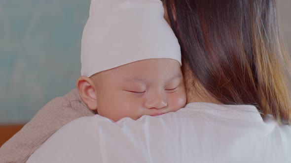 Mommy embracing baby boy carrying him in arms, enjoying Motherhood