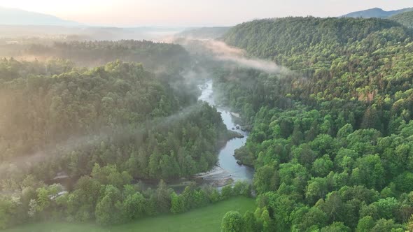 Flying over a river in mist on a beautiful sunrise
