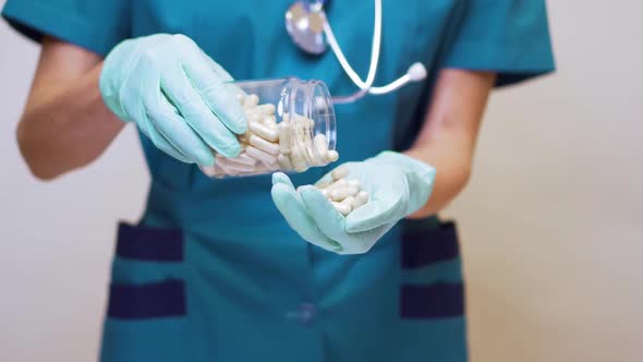 Medical Doctor Nurse Woman Wearing Protective Mask and Rubber or Latex Gloves - Holding Pills